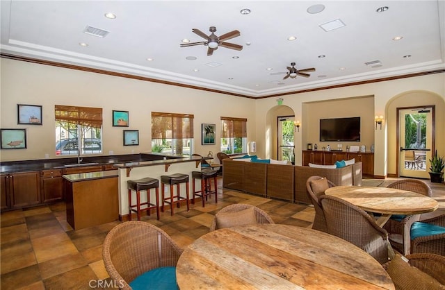 interior space featuring ceiling fan, crown molding, and sink