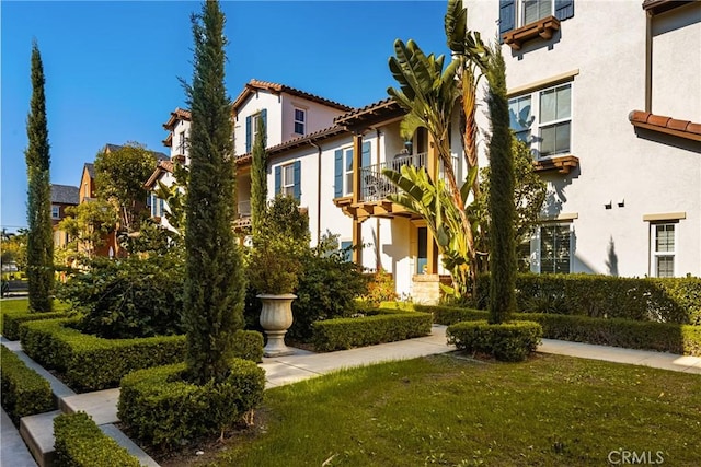 exterior space featuring a balcony and a front yard