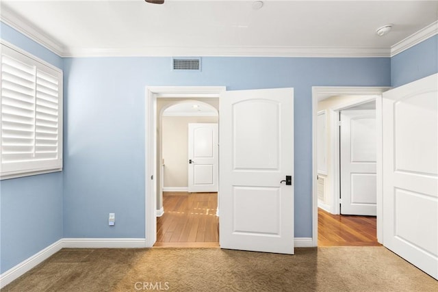 unfurnished bedroom featuring wood-type flooring and crown molding