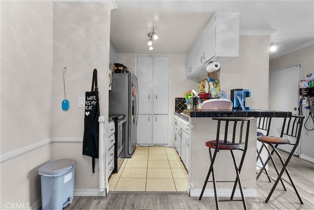kitchen featuring white cabinets, black range with electric stovetop, tile counters, and ornamental molding