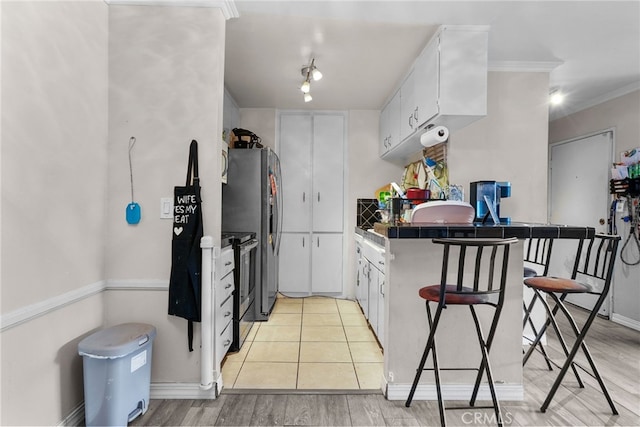 806 Coriander Dr Unit G, Torrance, CA 90502 - kitchen with white cabinetry, appliances with stainless steel finishes, ornamental molding, and light wood finished floors