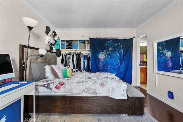 bedroom featuring ensuite bath, crown molding, dark wood-type flooring, and a closet