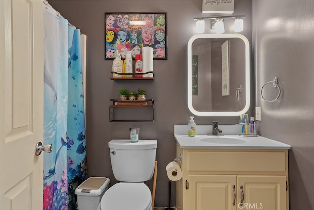 bathroom with a shower with shower curtain, vanity, and toilet