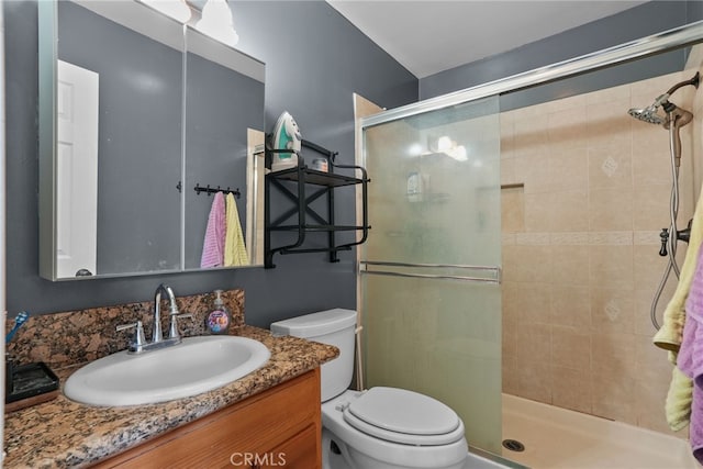 bathroom with toilet, vanity, and walk in shower
