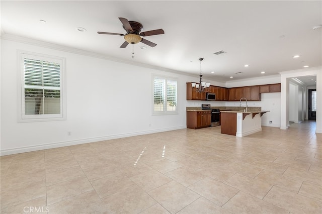 kitchen with stainless steel appliances, light stone counters, an island with sink, pendant lighting, and a breakfast bar area