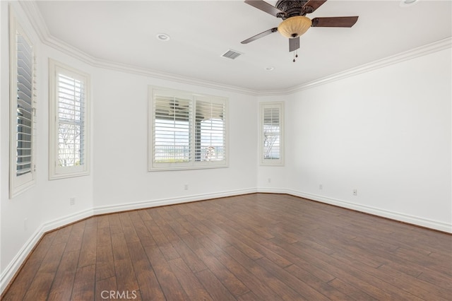 empty room with dark hardwood / wood-style flooring, plenty of natural light, and crown molding