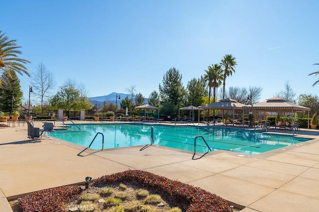 view of pool with a gazebo, a mountain view, and a patio