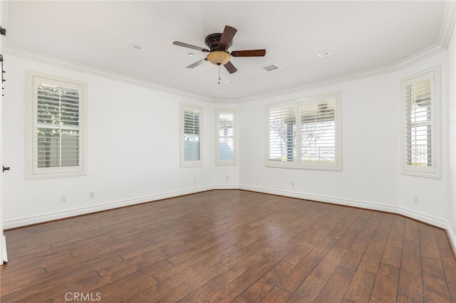 empty room with a wealth of natural light, dark hardwood / wood-style flooring, and crown molding