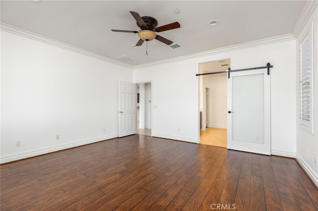 unfurnished bedroom featuring ornamental molding, a barn door, ceiling fan, and dark wood-type flooring