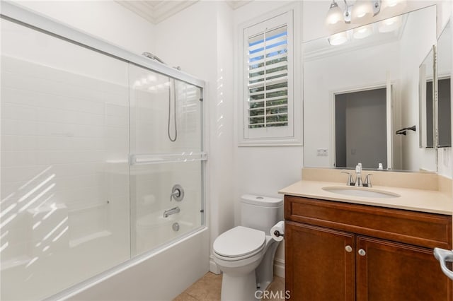 full bathroom featuring tile patterned flooring, crown molding, bath / shower combo with glass door, toilet, and vanity