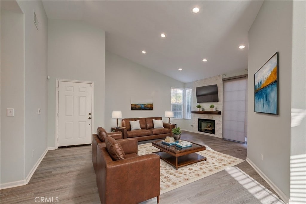 living room with hardwood / wood-style flooring and high vaulted ceiling