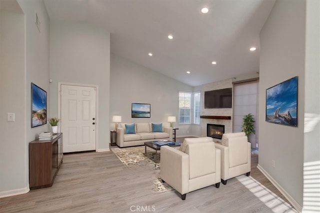 living room featuring light hardwood / wood-style floors and high vaulted ceiling