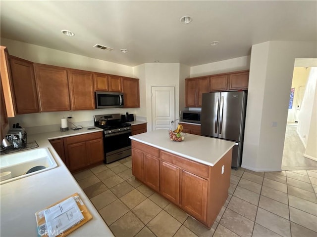 kitchen featuring a kitchen island, sink, stainless steel appliances, and light tile patterned flooring