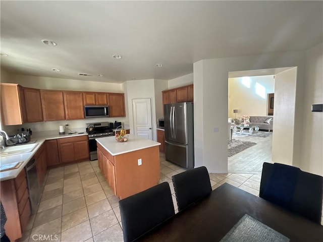 kitchen featuring a center island, light tile patterned floors, sink, and appliances with stainless steel finishes