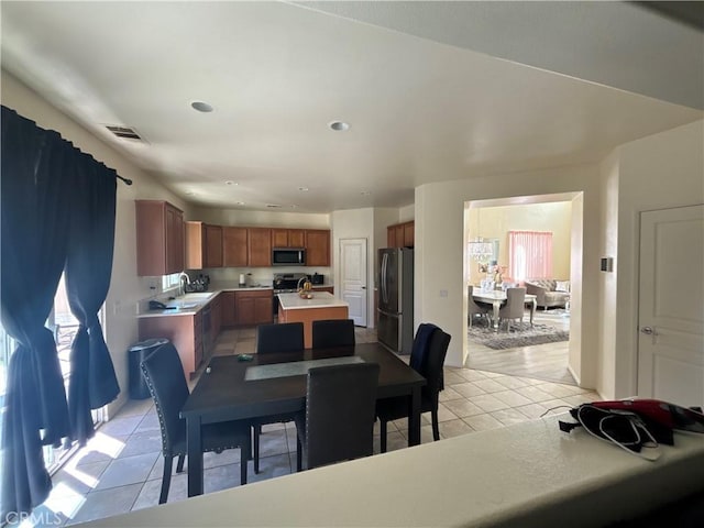 dining room with sink, light tile patterned flooring, and a healthy amount of sunlight