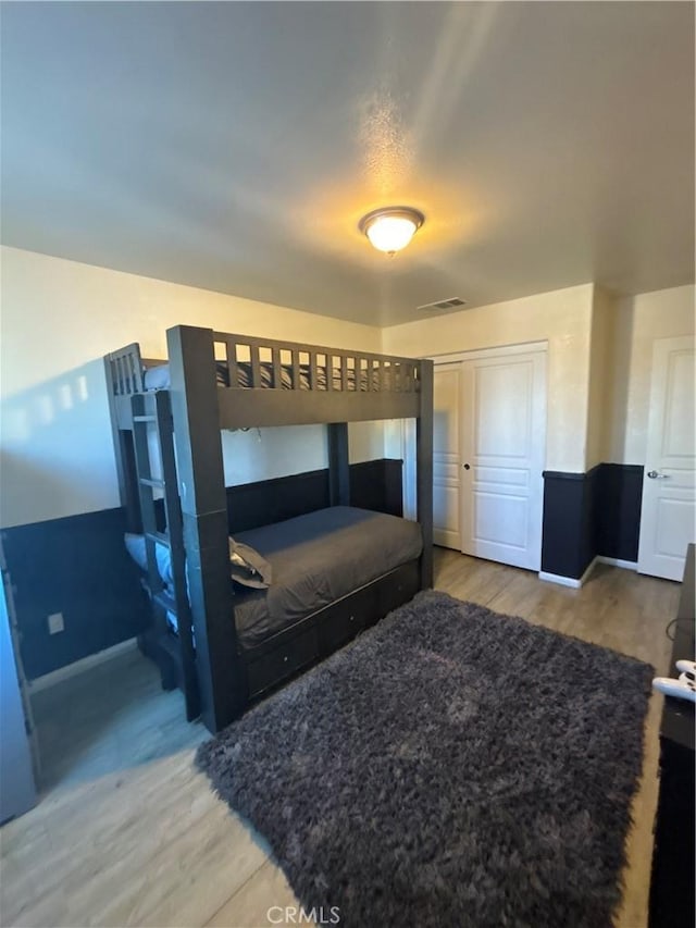 bedroom featuring wood-type flooring and a closet