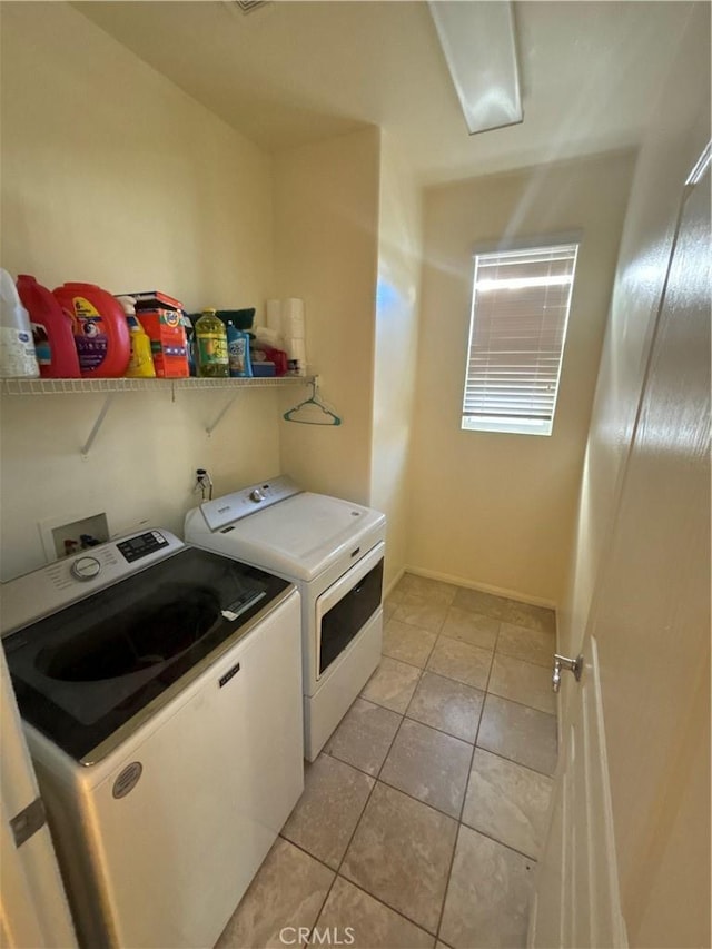 laundry area with washer and clothes dryer and light tile patterned flooring