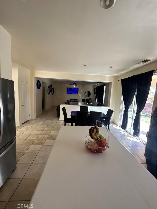 tiled dining area with ceiling fan