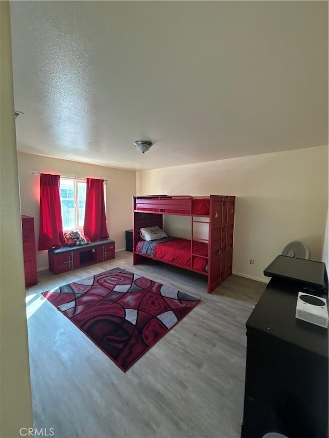 bedroom featuring light hardwood / wood-style floors and a textured ceiling