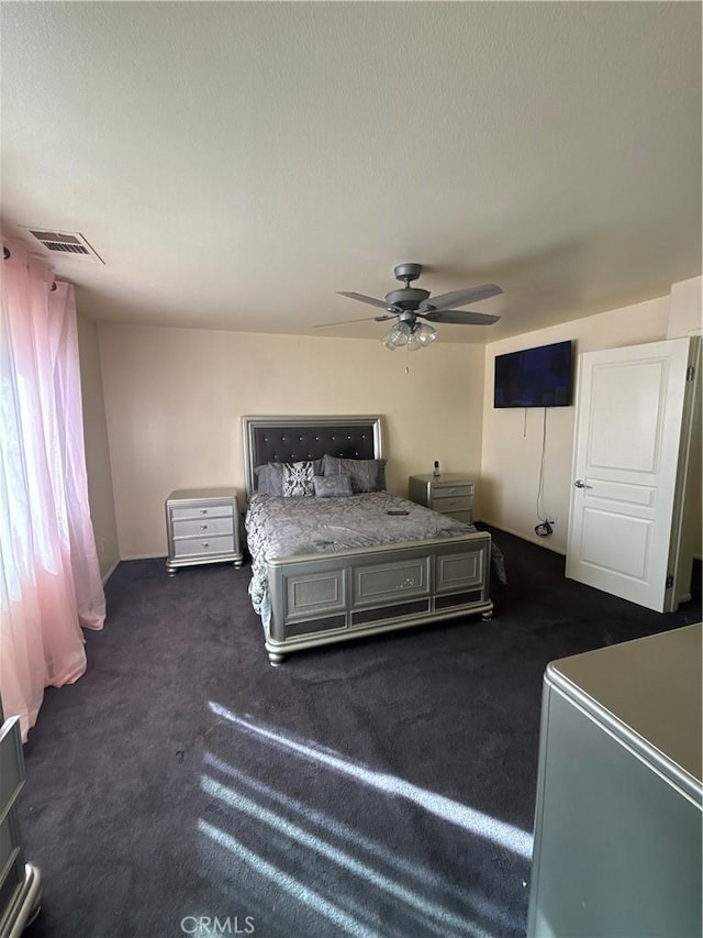 unfurnished bedroom featuring ceiling fan and dark carpet