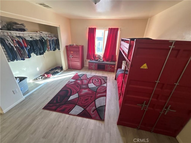 bedroom with light hardwood / wood-style floors and a closet