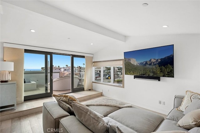 living room featuring vaulted ceiling with beams and light hardwood / wood-style floors