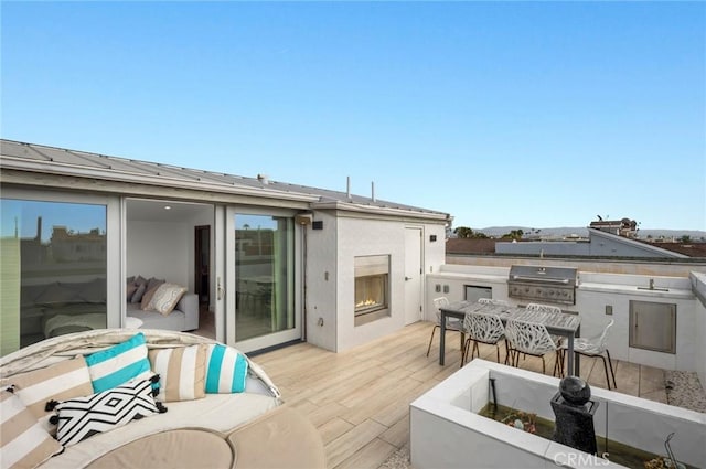 rear view of house with an outdoor living space with a fireplace