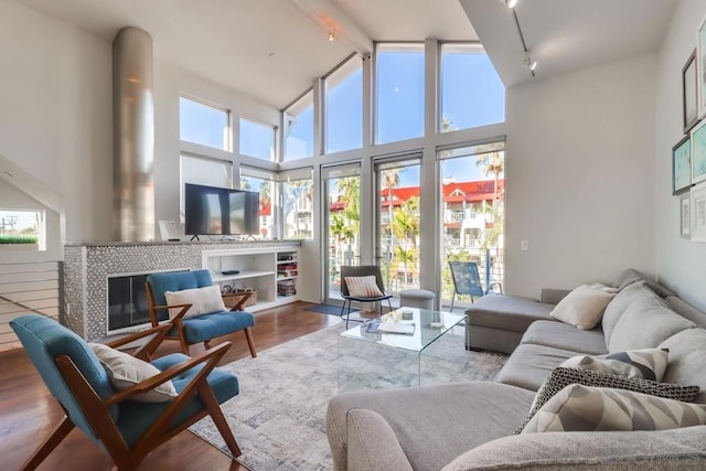 sunroom / solarium with a tile fireplace, plenty of natural light, and track lighting