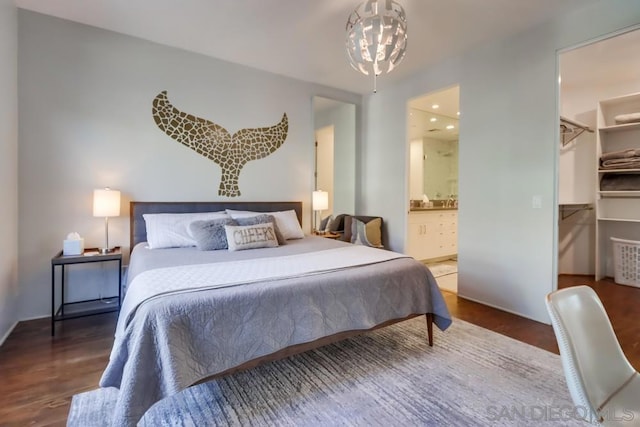 bedroom featuring a closet, dark hardwood / wood-style floors, ensuite bath, and a spacious closet