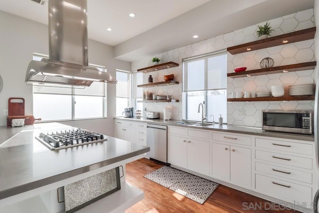 kitchen featuring sink, stainless steel appliances, light hardwood / wood-style floors, island range hood, and white cabinets