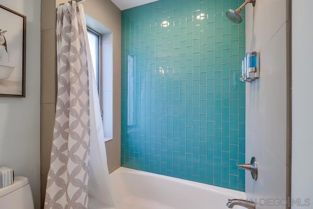 bathroom with toilet and shower / bath combo with shower curtain