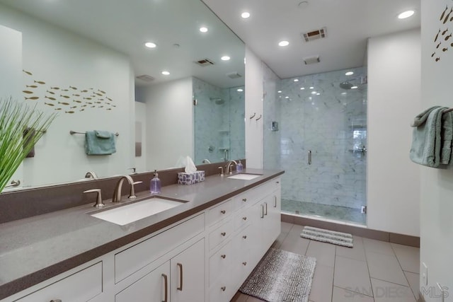 bathroom featuring tile patterned floors, vanity, and a shower with door