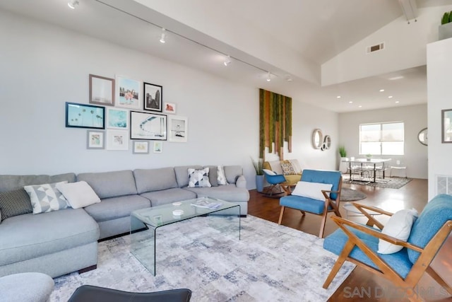 living room with track lighting, light hardwood / wood-style flooring, and vaulted ceiling