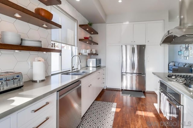 kitchen featuring white cabinetry, wall chimney range hood, sink, and appliances with stainless steel finishes