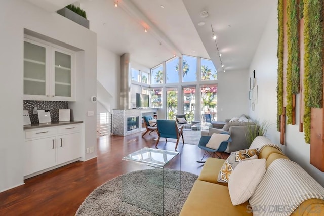 living room featuring dark hardwood / wood-style flooring, high vaulted ceiling, and beamed ceiling