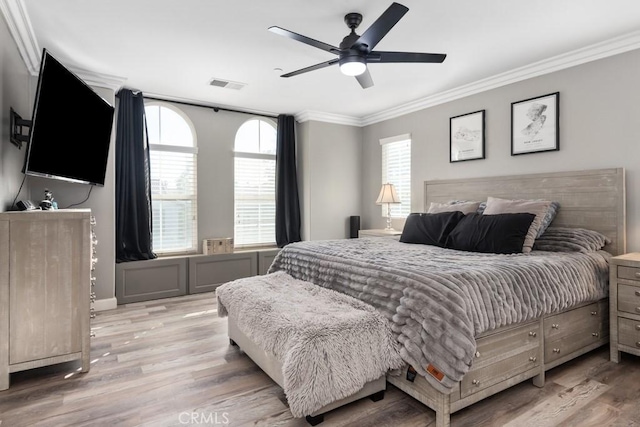 bedroom with crown molding, ceiling fan, and light hardwood / wood-style floors