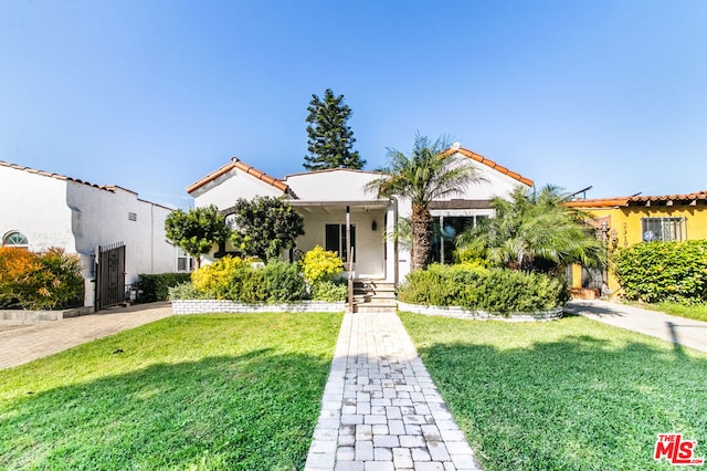 mediterranean / spanish house with a front lawn