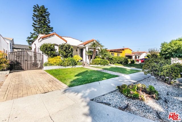 mediterranean / spanish home with a front lawn