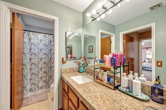 bathroom with tile patterned flooring, a shower with curtain, vanity, and toilet