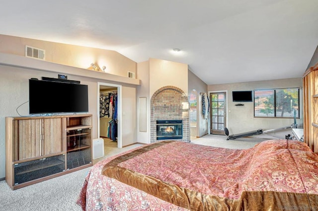 carpeted bedroom featuring a walk in closet, a closet, and lofted ceiling