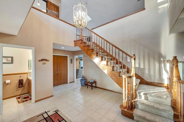 staircase with tile patterned flooring, a towering ceiling, and an inviting chandelier