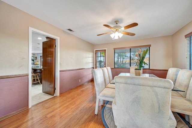 dining space with ceiling fan and light wood-type flooring