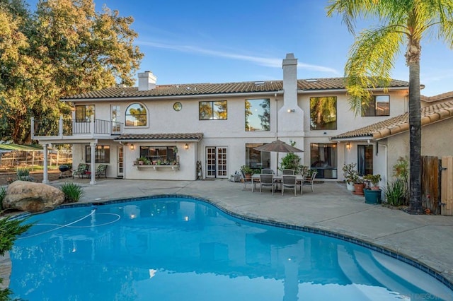 back of property featuring a balcony and a patio