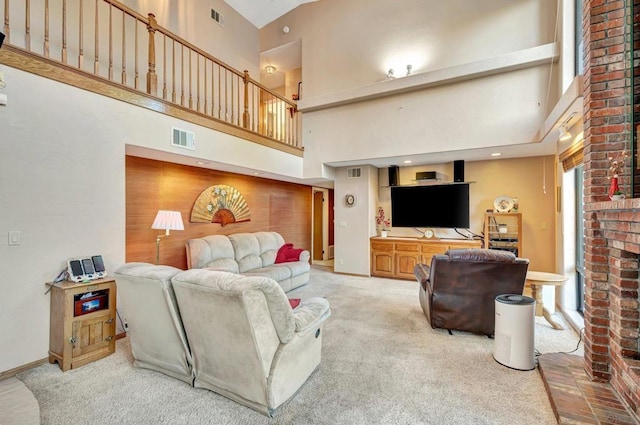 carpeted living room with a fireplace and a high ceiling