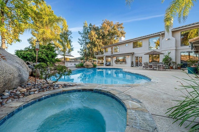 view of swimming pool with a patio area and an in ground hot tub