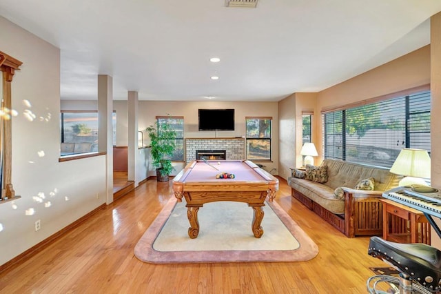 playroom featuring a fireplace, light wood-type flooring, and pool table