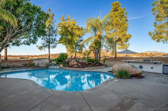 view of swimming pool featuring a mountain view and a patio area