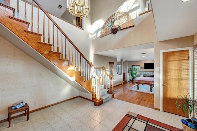 entrance foyer with a chandelier, hardwood / wood-style floors, and a towering ceiling