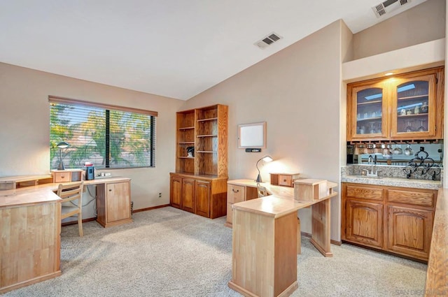 carpeted home office featuring lofted ceiling and sink