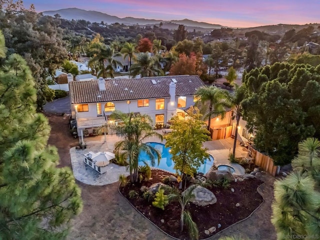 aerial view at dusk featuring a mountain view